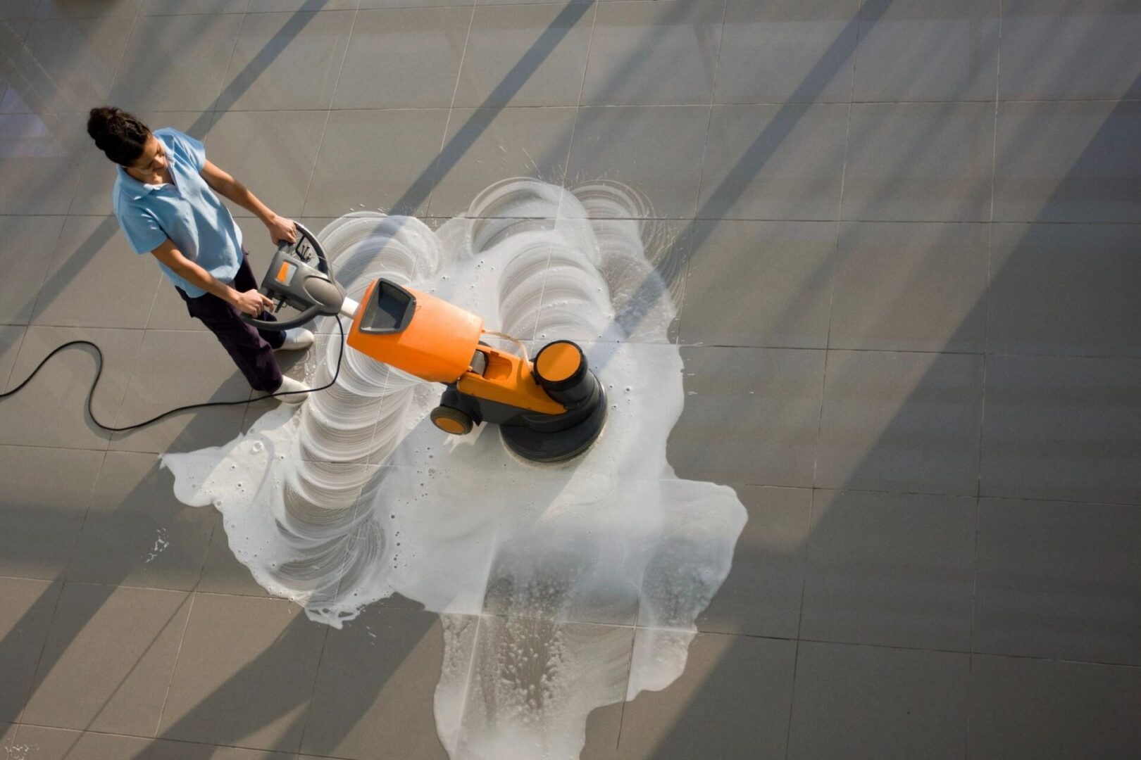 A person is using an industrial floor scrubber.