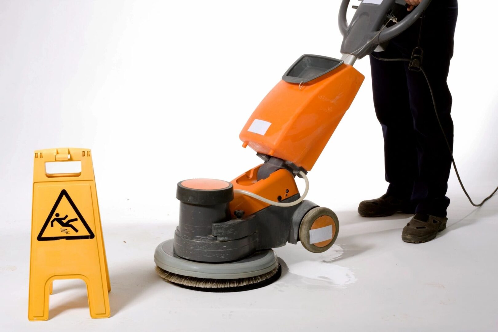 A man is using an orange machine to clean the floor.